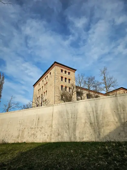Muro de borde y edificio recortados contra las nubes.