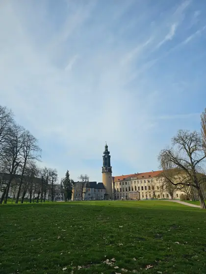 Pradera y edificios históricos como fondo del recorrido.