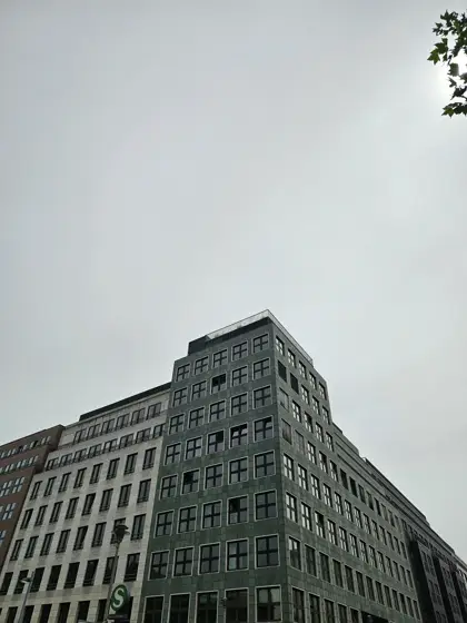 Volumen de oficinas y ventanas repetidas bajo un cielo gris.