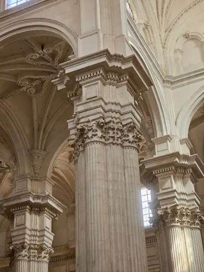 Pilares, arcos y luz lateral en el espacio de una iglesia.