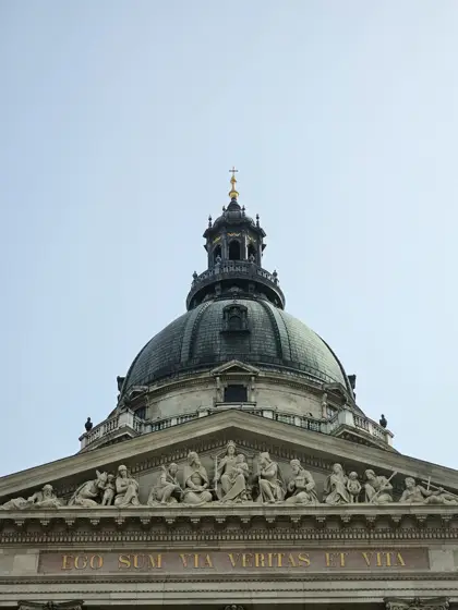 Cúpula y frontón sobre una fachada de composición clásica.