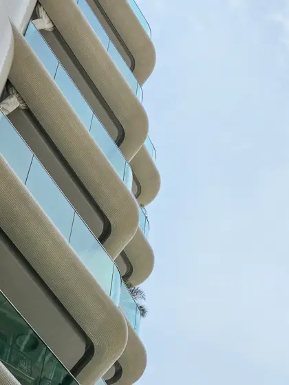 Curvas claras y vidrio en la piel del edificio.