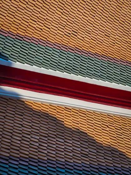 Franjas de tejas vidriadas: color y repetición en la cubierta.